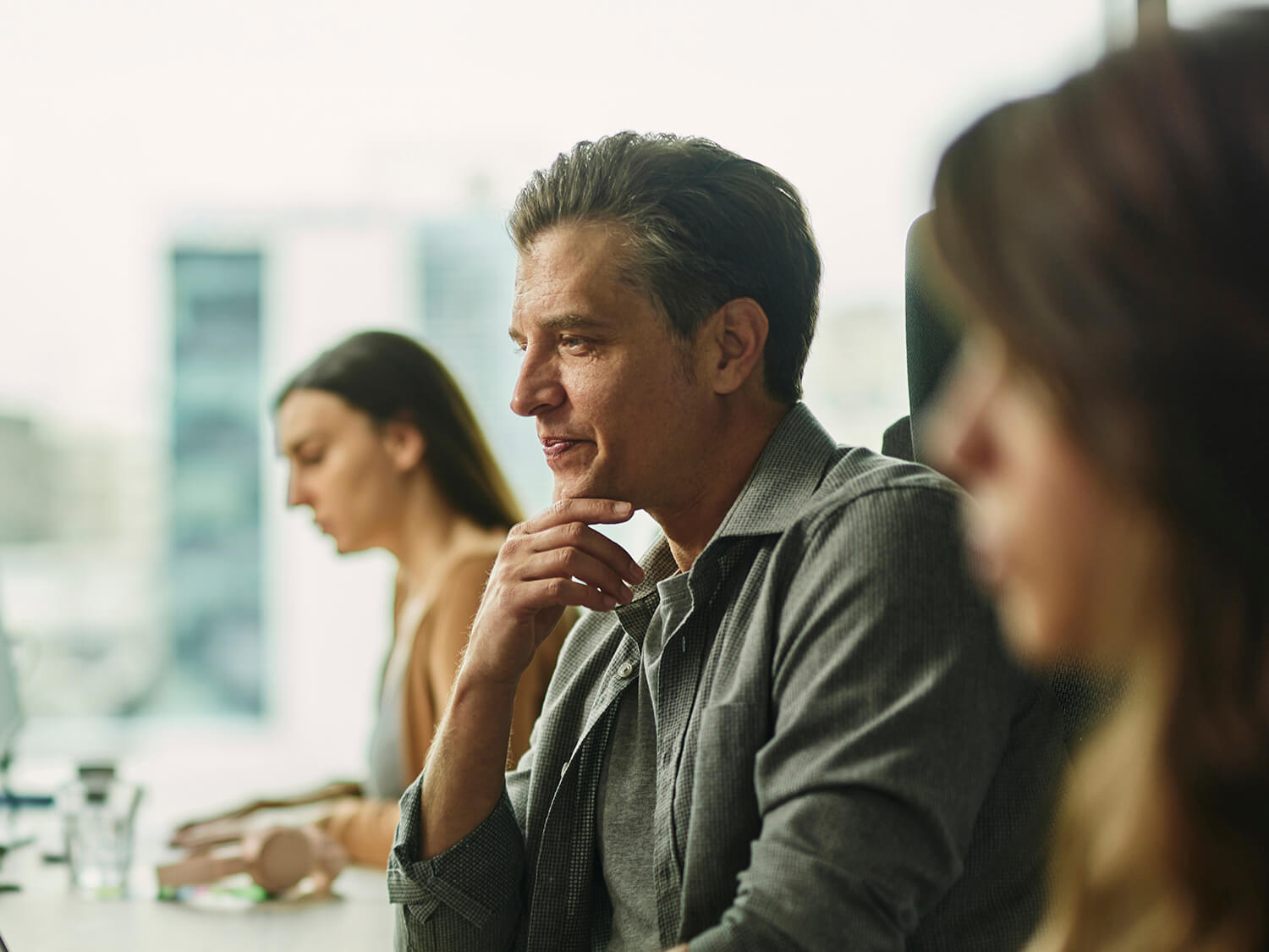 A man sat at a workstation with colleagues 